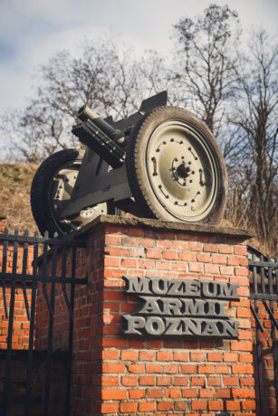 Na zdjęciu fragmenty działa ustawionego na ceglanym płocie przed wejściem do Muzeum Armii Poznań.