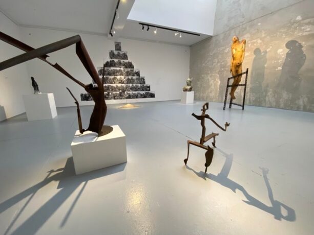 Grafika artykułu: zdjęcie wykonane w Galerii Sztuki Rozruch - widać na nim prezentowane rzeźby w ramach wystawy "Twórczy dotyk II – giganci współczesnej rzeźby", są punktowo oświetlone. 