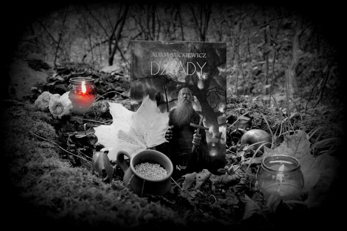 Grafika artykułu: Zdjęcie książki - "Dziady" Adama Mickiewicza na leśnym podłożu, wokół jesienne liście, jabłka, znicze, wszystko w kolorze czarno-białym, jedynie płomień w jednym ze zniczy ma kolor czerwony. W tle widać las.