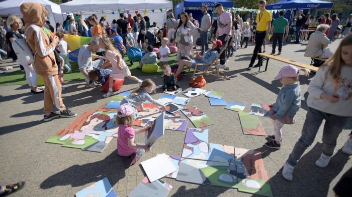 Grafika artykułu: Na zdjęciu Poznańskie Dni Rodziny - grupa dzieci na placu, układających wielkie puzzle. 