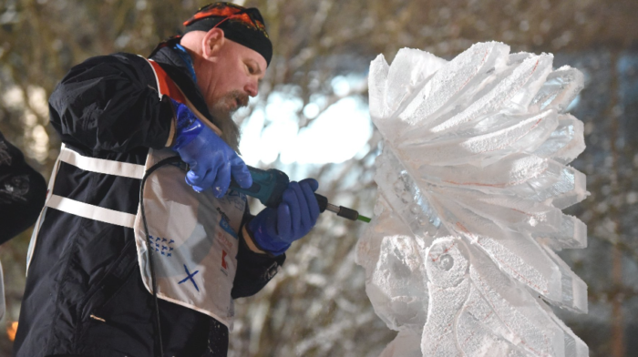 Grafika artykułu: po lewej mężczyzna w kurtce i czapce oraz niebieskich rękawicach. P prawej rzeźba z lodu. Mężczyzna trzyma narzędzie do rzeźbienia w lodzie, którym dotyka lodowej rzeźby.